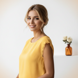 Close-up portrait of Yasmine Abadi, a woman with a warm smile, against a clean white background.