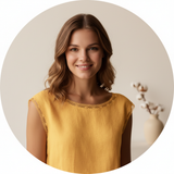 Circular portrait of Tessa Moore smiling, with soft waves in her hair, against a light cream background.